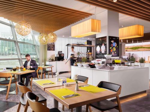 a man sitting at tables in a restaurant at Novotel Warszawa Centrum in Warsaw
