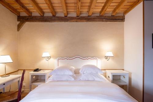 a bedroom with a white bed with two night stands at Le Champ des Oiseaux Hôtel & Spa in Troyes