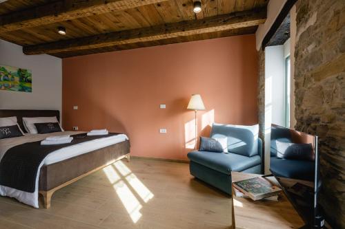 a bedroom with a bed and a couch and a chair at Villa Sofija in Kojsko
