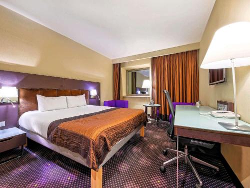 a hotel room with a bed and a desk at Mercure Gdańsk Stare Miasto in Gdańsk