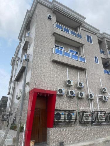 a tall building with windows and a red door at Complexe Ebouna-Pendza in Pointe-Noire