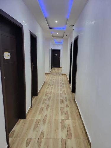 a hallway with white walls and a wooden floor at Complexe Ebouna-Pendza in Pointe-Noire