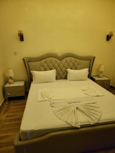 a large bed in a bedroom with two night stands at Complexe Ebouna-Pendza in Pointe-Noire
