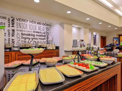 a buffet with many plates of food on a table at Mercure Gdańsk Stare Miasto in Gdańsk