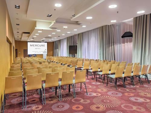 a conference room with chairs and a screen in it at Mercure Gdańsk Stare Miasto in Gdańsk