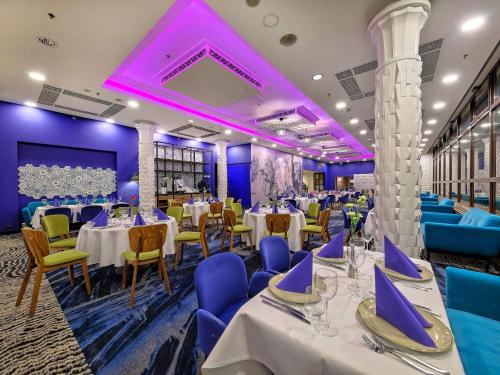a room with tables and chairs and purple lighting at Mercure Gdańsk Stare Miasto in Gdańsk