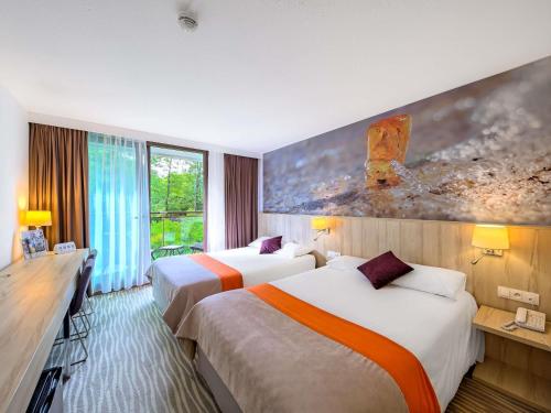 a hotel room with two beds and a large window at Mercure Gdańsk Posejdon in Gdańsk
