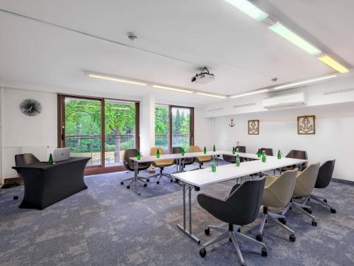 a conference room with a long table and chairs at Mercure Gdańsk Posejdon in Gdańsk