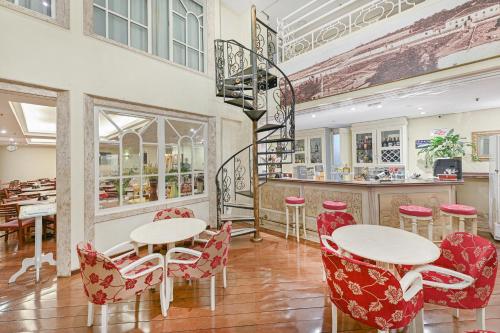 a restaurant with two tables and red chairs at Hotel Dan Inn Campinas Cambuí - Um Hotel Clássico em Campinas By Nacional Inn in Campinas