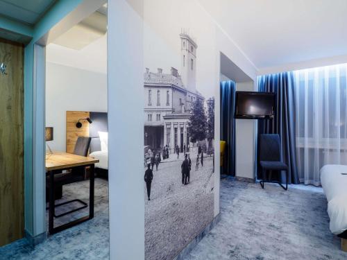 a hotel room with a mural of a city at Mercure Czestochowa Centrum in Częstochowa