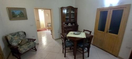 a dining room with a table and a chair at Il Giardino in Solarussa