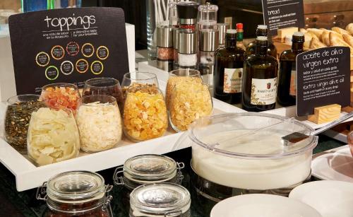 a table with jars of food and bottles of wine at NH Lleida Pirineos in Lleida
