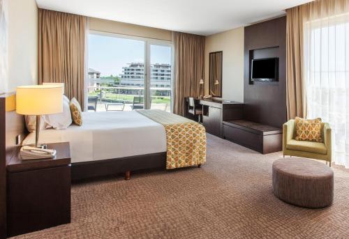 a hotel room with a large bed and a television at Wyndham Nordelta Tigre - Buenos Aires in Tigre