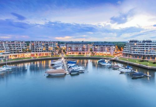 a group of boats docked in a river with buildings at Wyndham Nordelta Tigre - Buenos Aires in Tigre