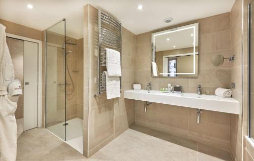 a bathroom with a sink and a shower at NH Collection Marseille in Marseille