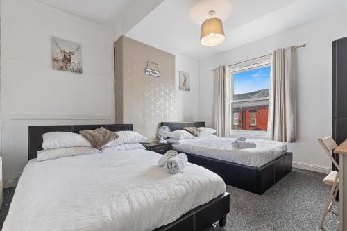 a bedroom with two beds and a window at Stylish 2-Bedroom Apartment in Leeds LS12, Perfect for Contractors & Extended Stays-F&K Property in Amley