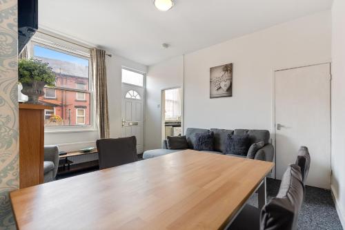 a living room with a table and a couch at Stylish 2-Bedroom Apartment in Leeds LS12, Perfect for Contractors & Extended Stays-F&K Property in Amley