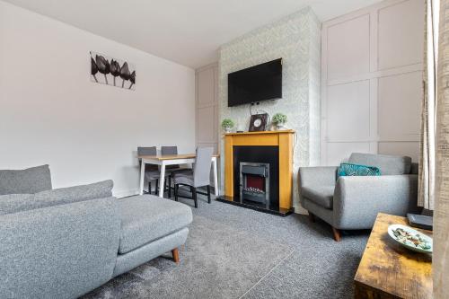 a living room with a couch and a fire place at Stylish 2-Bedroom Apartment in Leeds LS12, Perfect for Contractors & Extended Stays-F&K Property in Amley