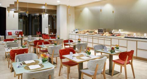 a restaurant with tables and chairs and a counter at NH Collection Marseille in Marseille