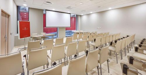 a conference room with chairs and a blank screen at NH Collection Marseille in Marseille