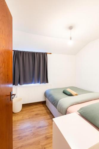 a bedroom with two beds and a window at Beautiful 4 bedrooms house, 7 walk to train station in Plumstead