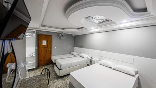 a room with two beds and a flat screen tv at Hotel Monte Palma - São Paulo Próximo a Arena Neo Química in Sao Paulo