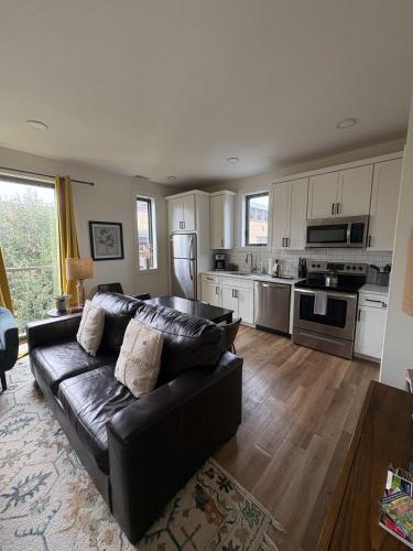 a living room with a leather couch and a kitchen at Downtown Traverse City Capri Condo 316 in Traverse City