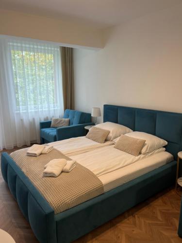 un grande letto in una camera da letto con testiera blu di PLANETA 202 - tylko 100 m do GŁÓWNEGO DEPTAKU i plaży! a Mielno