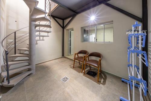 een kamer met een wenteltrap en twee stoelen bij B Homy Alegre in Sao Paulo