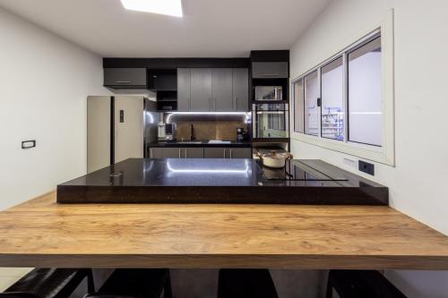 een keuken met een houten aanrechtblad en een koelkast bij B Homy Alegre in Sao Paulo