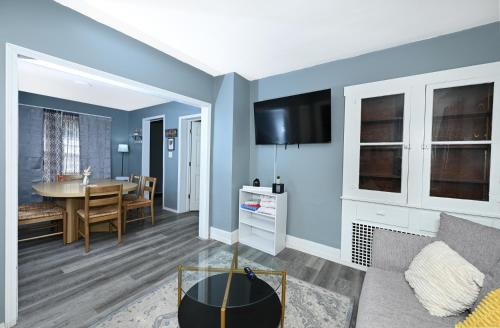 a living room with blue walls and a dining room at Firestone Park Home in Akron