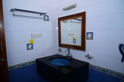 a bathroom with a black sink and a mirror at Sky villa stay in Mysore