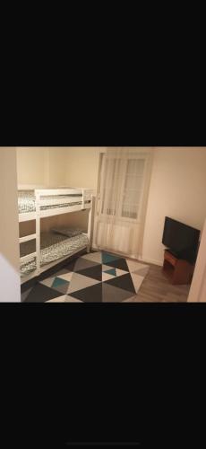 a room with a black and white floor and a tv at Aya in Pompey