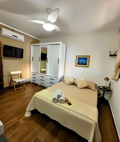 a bedroom with a bed with a dresser and a tv at Acesso à Praia Ar Condicionado Conforto Garantido! in Saquarema