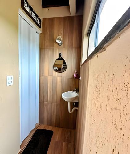 a small bathroom with a sink and a mirror at Acesso à Praia Ar Condicionado Conforto Garantido! in Saquarema
