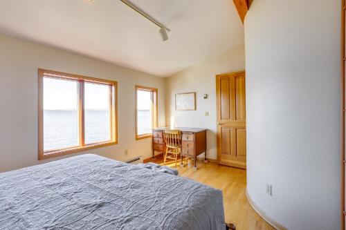 a bedroom with a bed and a desk and windows at 9 Mi to Mendenhall Glacier Waterfront Juneau Home in Juneau International Airport