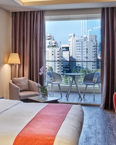 Una habitación de hotel con una cama y una ventana grande. en Hotel Bel Wood Near Delhi IGI, en Nueva Delhi