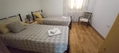 a small room with two beds and a chair at Il Giardino in Solarussa