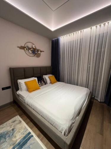 a bed with two yellow pillows in a bedroom at The Diamond In City Luxury Suites By ZENORA Living in Accra