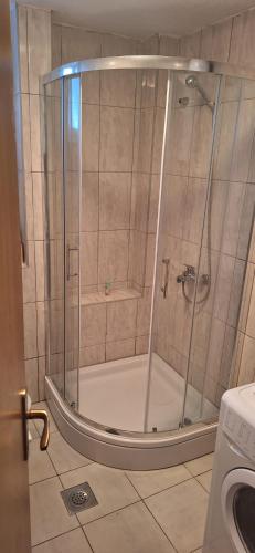 a shower with a glass door in a bathroom at Apartman KULA Livno in Livno