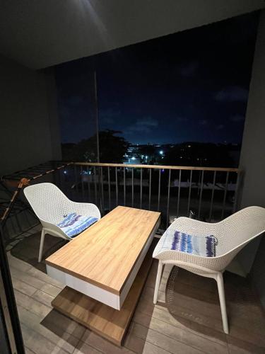 two chairs and a wooden table on a balcony at The Diamond In City Luxury Suites By ZENORA Living in Accra