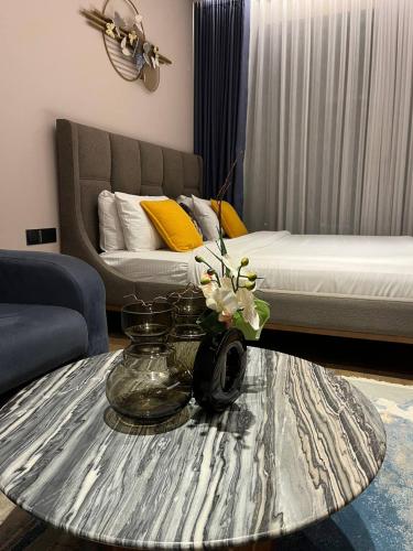 a living room with a coffee table and a bed at The Diamond In City Luxury Suites By ZENORA Living in Accra