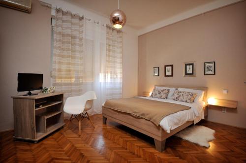 Schlafzimmer mit einem Bett, einem Schreibtisch und einem TV in der Unterkunft Celtis Apartment in Split