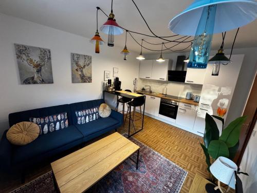 a living room with a blue couch and a kitchen at Ferienwohnung Casa Perla in Veitsbronn