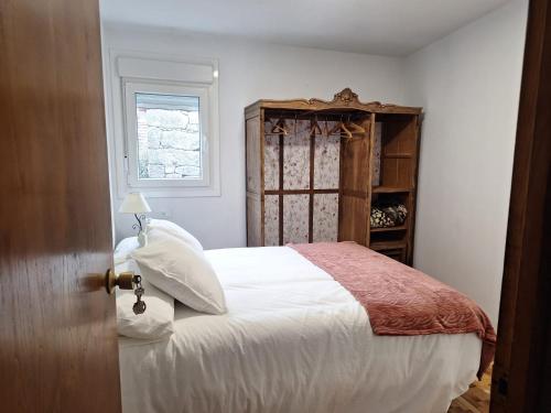 a bedroom with a white bed and a window at Casa María in Baltar