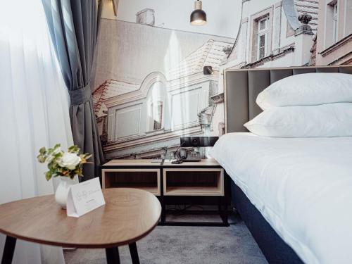 a hotel room with a bed and a table at Mercure Jelenia Góra in Jelenia Góra