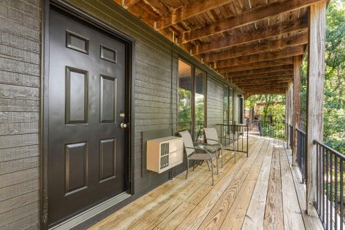 a screened porch with a black door and chairs at Compton Ridge Lodge in Branson