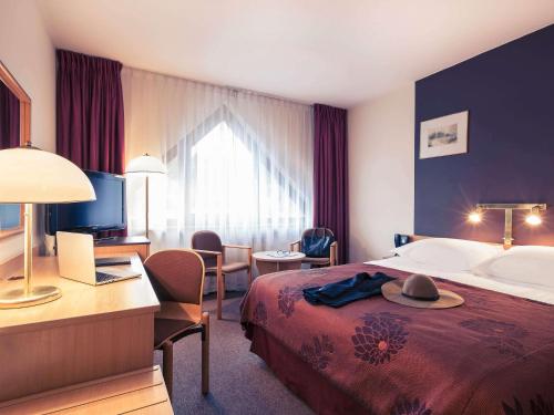 a hotel room with a bed with a hat on it at Mercure Jelenia Góra in Jelenia Góra