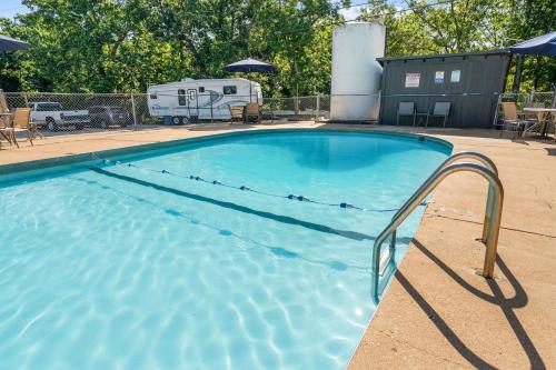a swimming pool with an rv and a trailer at Compton Ridge Lodge in Branson