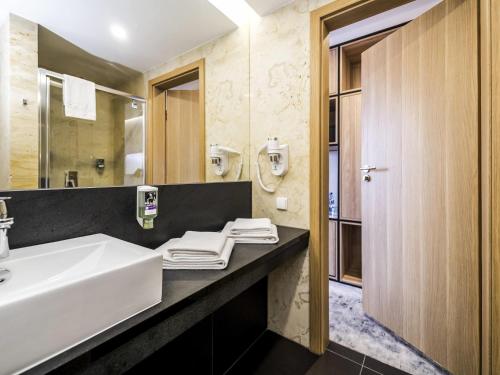 a bathroom with a sink and a mirror at Mercure Jelenia Góra in Jelenia Góra